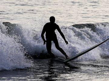 A person surfs, Saturday, Oct. 22, 2022, in the Far Rockaway neighborhood of the Queens borough of New York. 