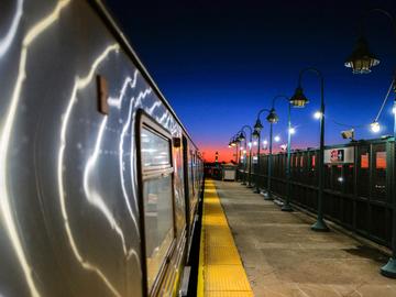 The sunset is seen from the platform of a subway train station in Rockaway in the Queens borough of New York on February 14, 2024. 