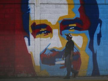 A man walks past a graffiti depicting Venezuelan President Nicolas Maduro in Caracas on January 3, 2026.