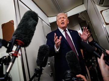 U.S. President Donald Trump takes questions from the members of the press aboard Air Force One on January 11, 2026 en route back to the White House from Palm Beach, Florida.