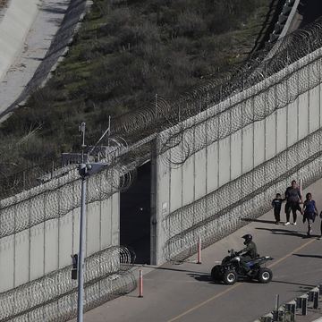 In this Dec. 16, 2018, file photo, Honduran asylum seekers are taken into custody by U.S. Border Patrol agents after the group crossed the U.S. border wall into San Diego, in California