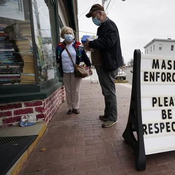 Shoppers comply with the mask regulations to help prevent the spread of the coronavirus at Bridgton Books, Friday, Nov. 13, 2020, in Bridgton, Maine. 