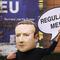 A campaigner from the global citizens movement Avaaz wearing a mask of Facebook CEO Mark Zuckerberg holds a sign reading 'Regulate me' on Tuesday, Dec. 15, 2020 in Brussels.