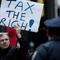 A protester holds a 'Tax the Rich' sign as he marches during a rally against budget slashing held by union supporters on March 24, 2011 in New York City
