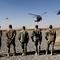 Officers and high-level NCOs wait in line as the helicopter of Commander of U.S. forces in Afghanistan General David Petraeus and his entourage land