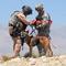 Left, 1st Sgt. Dean Bissey hooks the hoist harness to Staff Sgt. Michael Hile and his military working dog 