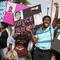 In this March 22, 2013 photo, protestors, Lakesha Hall, 32, of Sanford, center, and her son, Calvin Simms, 12, right, gather for a rally for Trayvon Martin, the black teenager who was fatally shot.
