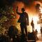 Protestors demonstrate outside of a burning fast food restaurant, Friday, May 29, 2020, in Minneapolis.