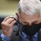 Director of the National Institute of Allergy and Infectious Diseases Dr. Anthony Fauci takes off his face mask before testifying before a House Committee on Energy and Commerce.