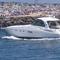 In this June 28, 2020, a yacht cruises through the Manasquan Inlet as a large crowd fills the beach in Manasquan, N.J. 