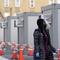 A worker wear a protective face shield walks between portable units set up for registration and testing at a New York City Health + Hospitals COVID-19 testing site in the Brooklyn borough of New York,