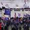 Crowds of rioters at the Capitol wave Trump 2020 flags and American flags.