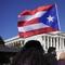 A woman waves the flag of Puerto Rico during a news conference on Puerto Rican statehood on Capitol Hill in Washington, Tuesday, March 2, 2021. 