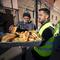 Church volunteers serve garlic bread to migrants camping outside the Sacred Heart Church in downtown El Paso, Texas, Sunday, Jan. 8, 2023.