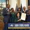 This image provided by the Office of The Governor, shows New York Gov. Kathy Hochul, seated center, after she signed a bill, in New York, Tuesday, Dec. 19, 2023, to create a reparations commission.