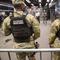 Members of the Armed Forces, including the National Guard, patrol the subway system in Penn Station as police officers check commuters' bags in New York on Thursday, March 7, 2024.