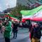  People wave flags as they demonstrate in support of the Iranian government on March 22, 2026 in central Tehran, Iran. 
