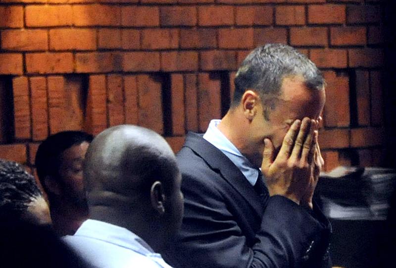 South Africa's Olympic sprinter Oscar Pistorius hides his face in his hands in the court room during his hearing on charge of murdering his model girlfriend Reeva Steenkamp.