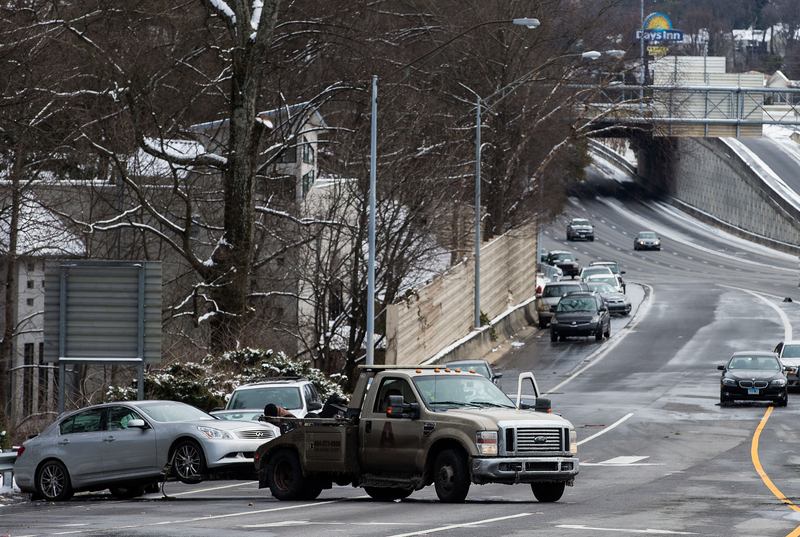 A tow truck pulls an abandoned vehicle on an exit ramp along I-75 North during the winter storm January 29, 2014 in Atlanta, Georgia