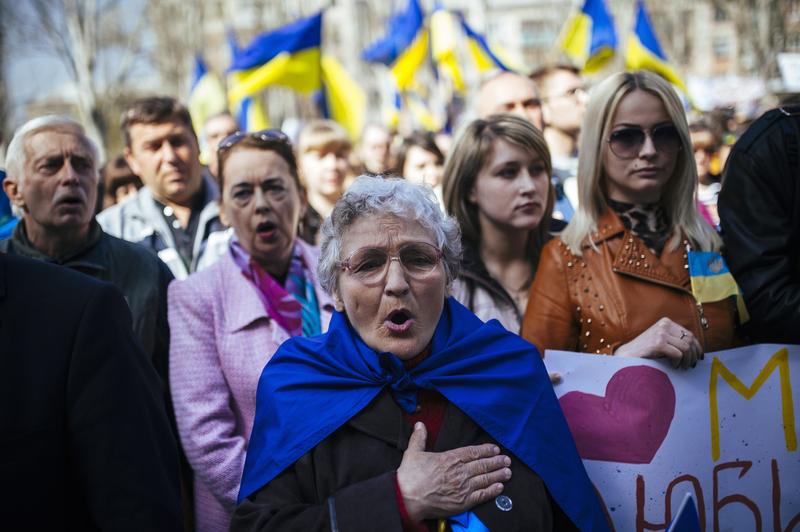 Ukrainian people sing their national anthem during a nationalist and pro-unity rally in the eastern city of Lugansk on April 17, 2014. 