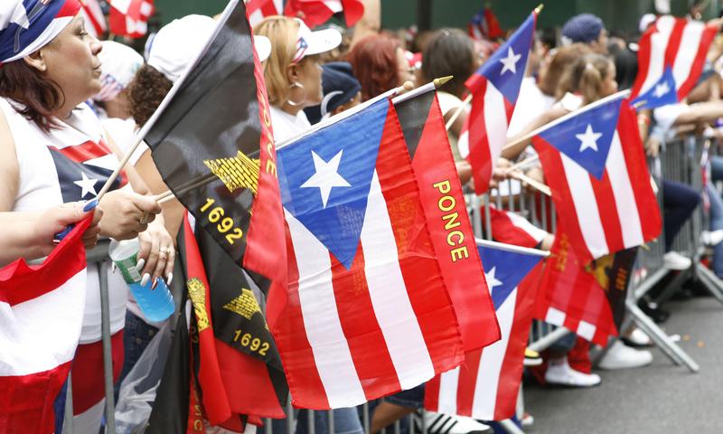 People wave flags during the National Puerto Rican Day Parade in New York City.