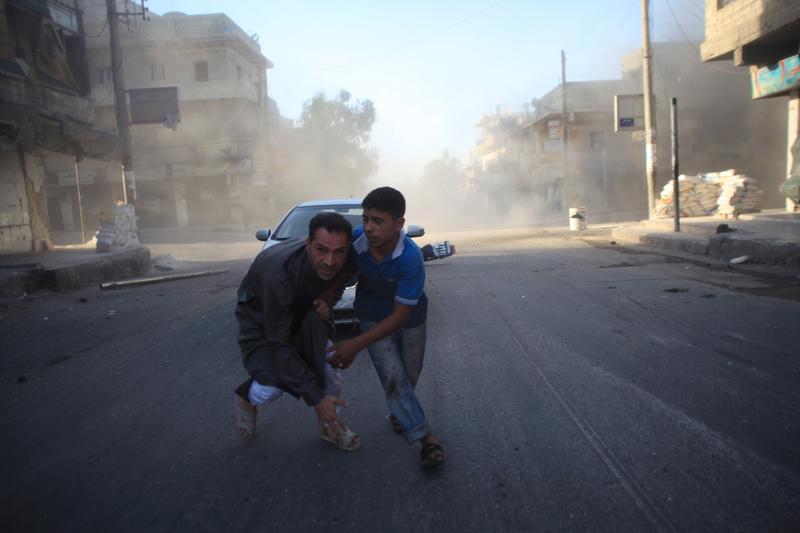 Syrian men react during a reported air strike by government forces in Aleppo on July 15, 2014. More than 170,000 people have been killed in the three-year Syrian war, one third of them civilians.