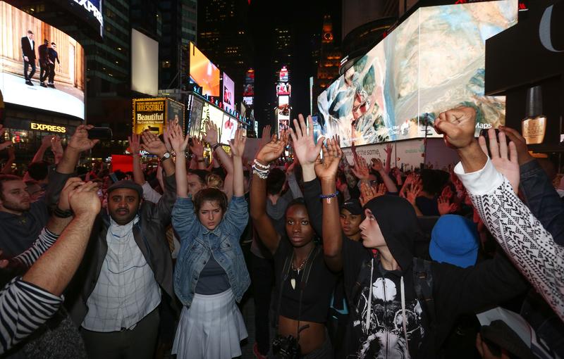 Protesters raise their hands as they march from Union Square to Times Square to protest a grand jury's decision not to indict a Ferguson police officer Darren Wilson in the shooting of Michael Brown 