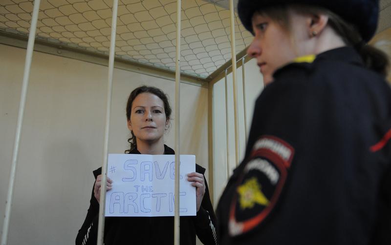 Greenpeace International activist, one of the 'Arctic 30,' Ana Paula Alminhana Maciel from Brazil, holds a poster in a defendant cage in a court in Saint Petersburg, Russia, November 18, 2013.