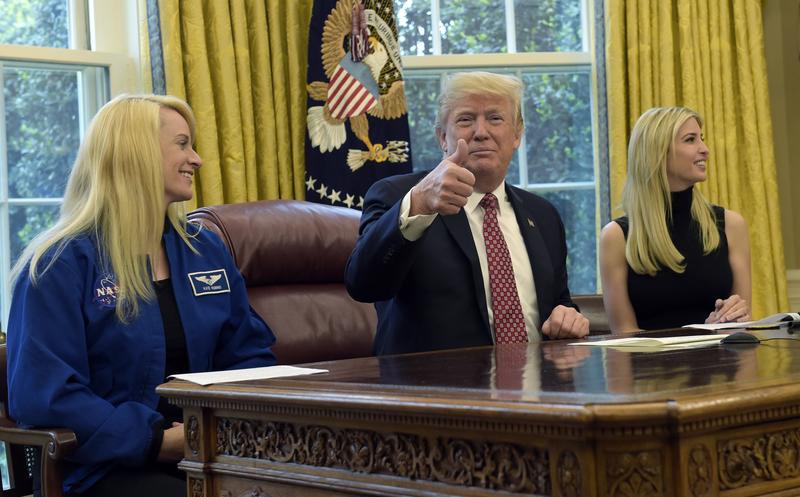 President Donald Trump, flanked by NASA astronaut Kate Rubins, left, and his daughter Ivanka Trump, gives a thumbs up following a video conference with the International Space Station.