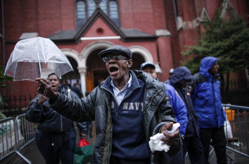 A man mourns outside Akai Gurley's funeral in December. 