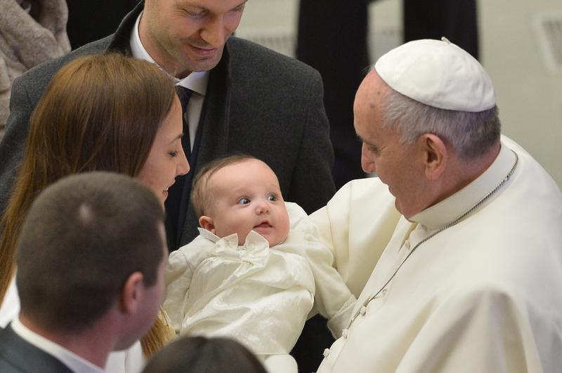 Pope Francis holds a baby at the end of his weekly general audience at the Paul VI hall on January 7, 2015 at the Vatican.