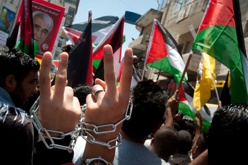Palestinians marching in Ramallah wear chains around their wrists to symbolize their solidarity with prisoners incarcerated by Israel, May 15, 2012.