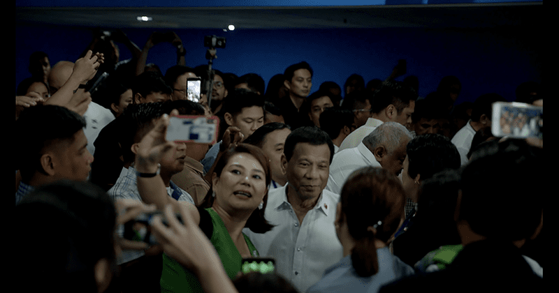 Philippine President Rodrigo Duterte posing for selfies with allies at the Commission of Elections.
