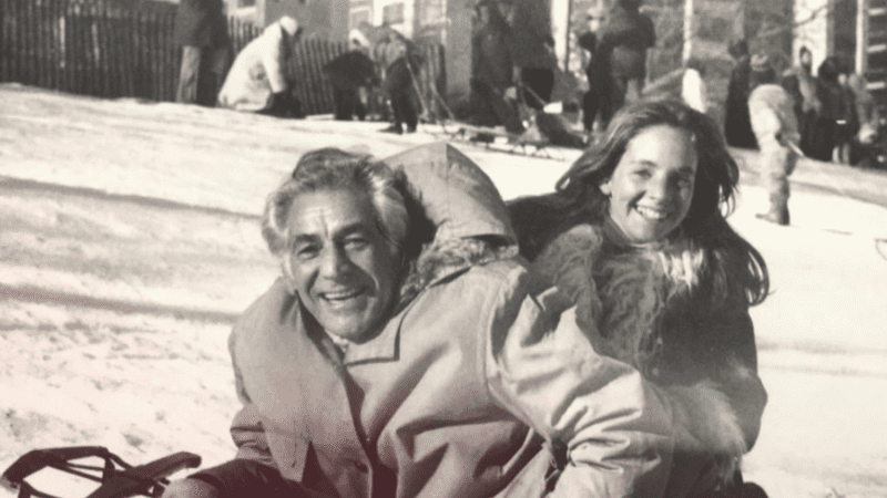 Jamie and Leonard Bernstein on a sled in Central Park; Photo by Lee Radziwill. 