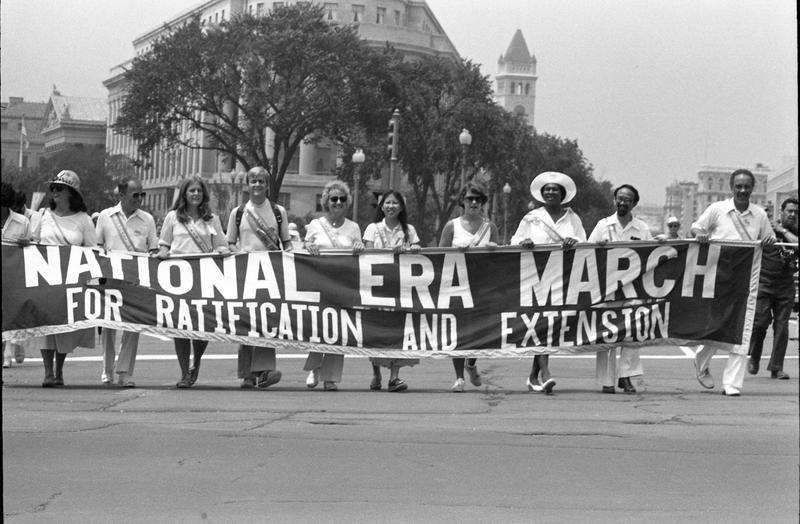 View of demonstrators as they carry a banner on Pennsylvania Avenue during the Equal Rights Amendment March, Washington DC, July 9, 1978.