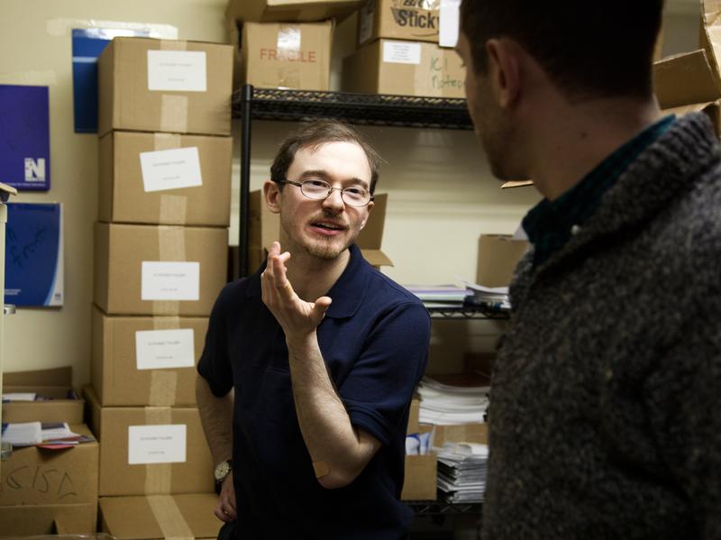 Jonathan Keleher talks with a colleague, Rafael Wainhaus, at work. Keleher was born without a cerebellum, but his brain has developed work-arounds for solving problems of balance and abstract thought.