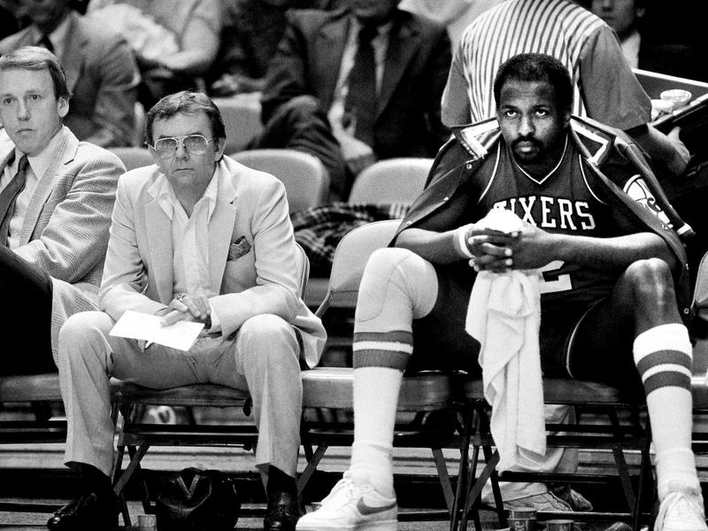 Moses Malone (right) rests on the bench during a game against the New York Knicks in 1984. Malone, a three-time NBA MVP, has died at the age of 60.