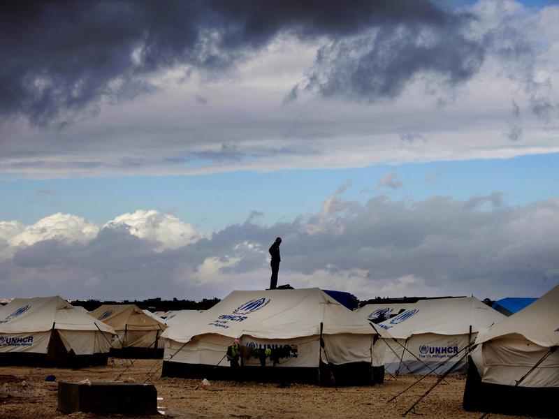 A Syrian refugee stands on top of a water tank at the Zaatari refugee camp in Jordan in 2013. While the surge of Middle Eastern refugees into Europe has grabbed world attention this year, most refugees find shelter close to their homeland, where they often remain for many years.