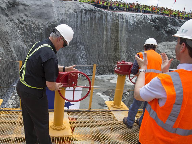 The head of the Panama Canal Authority, Jorge Quijano, center, opens the main valve to allow water into the flood chambers on the new set of locks on the Atlantic side of the Panama Canal in June 2015. The expansion of the canal, making it wider and deeper to accommodate larger ships, has taken nearly a decade. It opens next month.