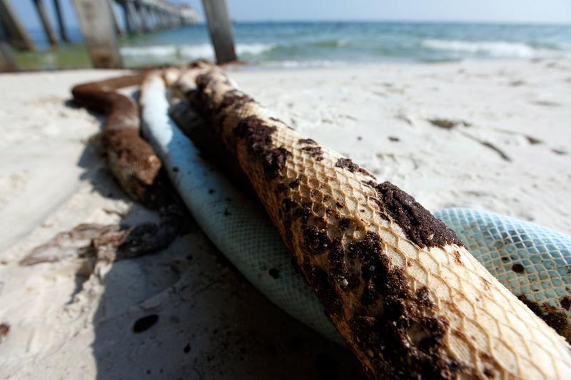 Oil soaked boom full of tar balls is seen near a pier on the beach on June 14, 2010 in Gulf Shores, Alabama. 