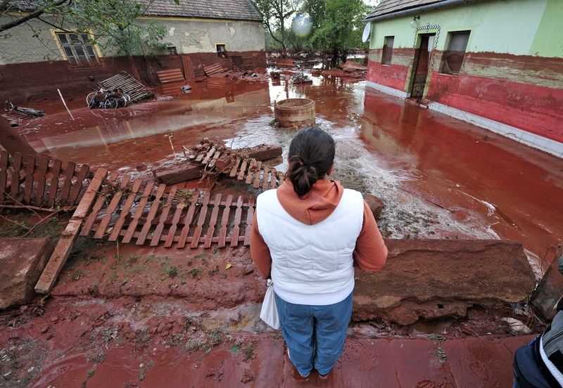 A woman contemplates the damage in Devecser, about 150 kms southwest of Budapest, on October 5, 2010 after the village was flooded on October 4 by toxic red sludge from a local aluminium plant.