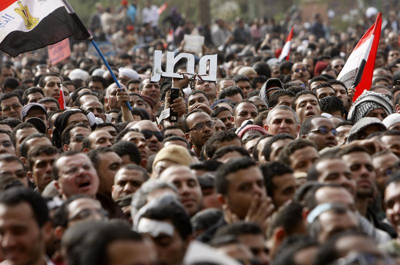 Egyptian anti-government protesters hold up the name of Egypt in Arabic at Tahrir Square during a protest in Cairo on February 4, 2011. 