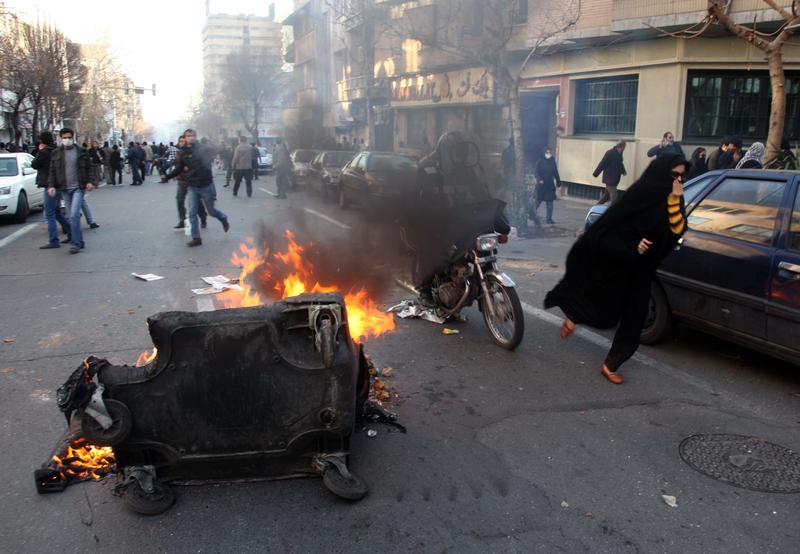 A garbage container is set on fire as Iranian protesters stage an anti-government demonstration, under the pretext of rallies supporting Arab uprisings, in Tehran on February 14, 2011.