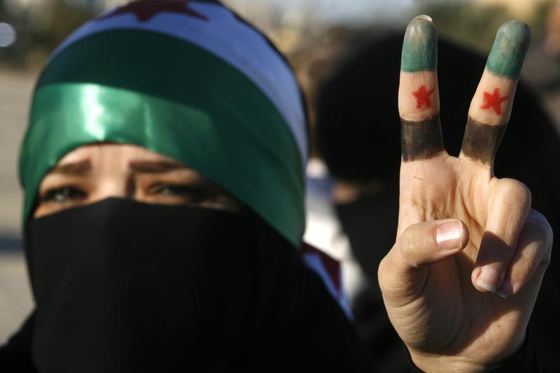 A woman flashes the V for 'victory' sign in protest against the Syrian regime.