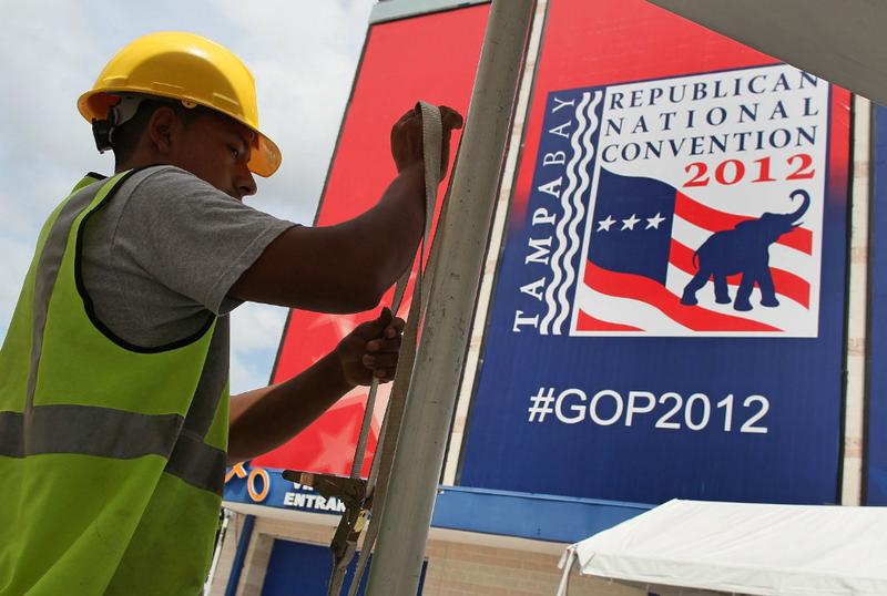 A worker secures a tent for the Republican National Convention at Tampa Bay Times Forum as the region prepares for Tropical Storm Isaac.