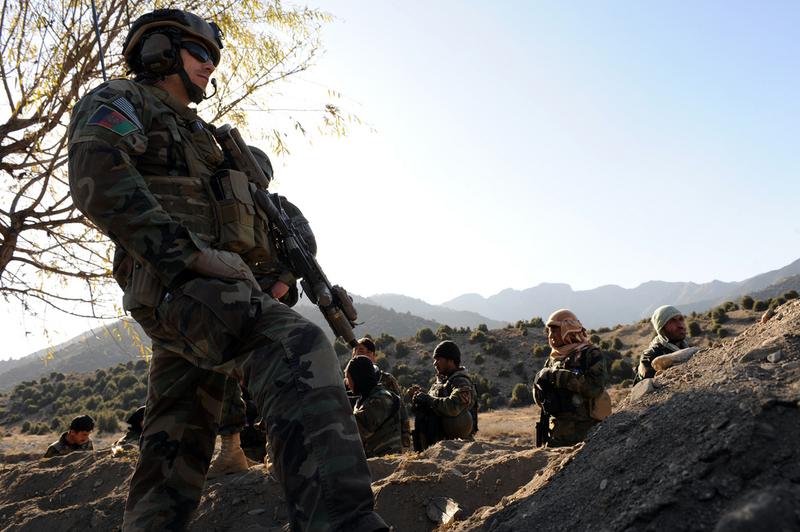 A U.S. Army Special Forces Soldier watches Afghan Commandos while patrolling a village in Paktia province, Afghanistan near the Pakistan border, on Nov. 30.