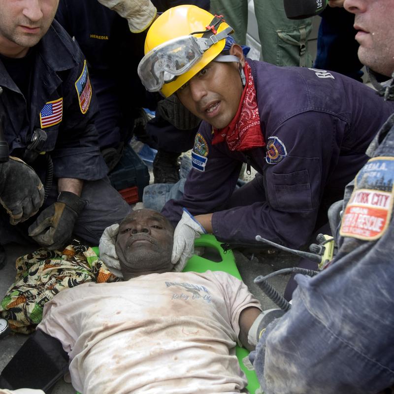 A man is rescued by members of New York City's Urban Rescue Team and Spanish and Taiwanese rescue teams January 17, 2010 in downtown Port Au Prince, Haiti.