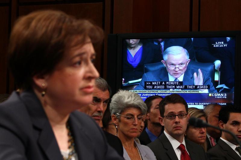 Elena Kagan (L) listens to a question from U.S. Sen. Jeff Sessions (R-AL) (on screen) on the second day of her confirmation hearings on Capitol Hill.