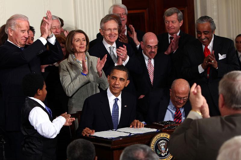 U.S. President Barack Obama (C) is applauded after signing the Affordable Health Care for America Act during a ceremony with fellow Democrats in the East Room of the White House