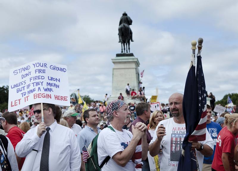 Protesters gather and hold signs during the Tea Party Express rally on September 12, 2009 in Washington, DC.
